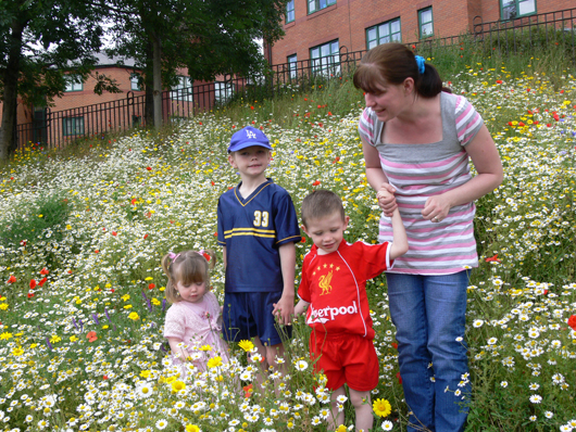 children in flower meadow in city